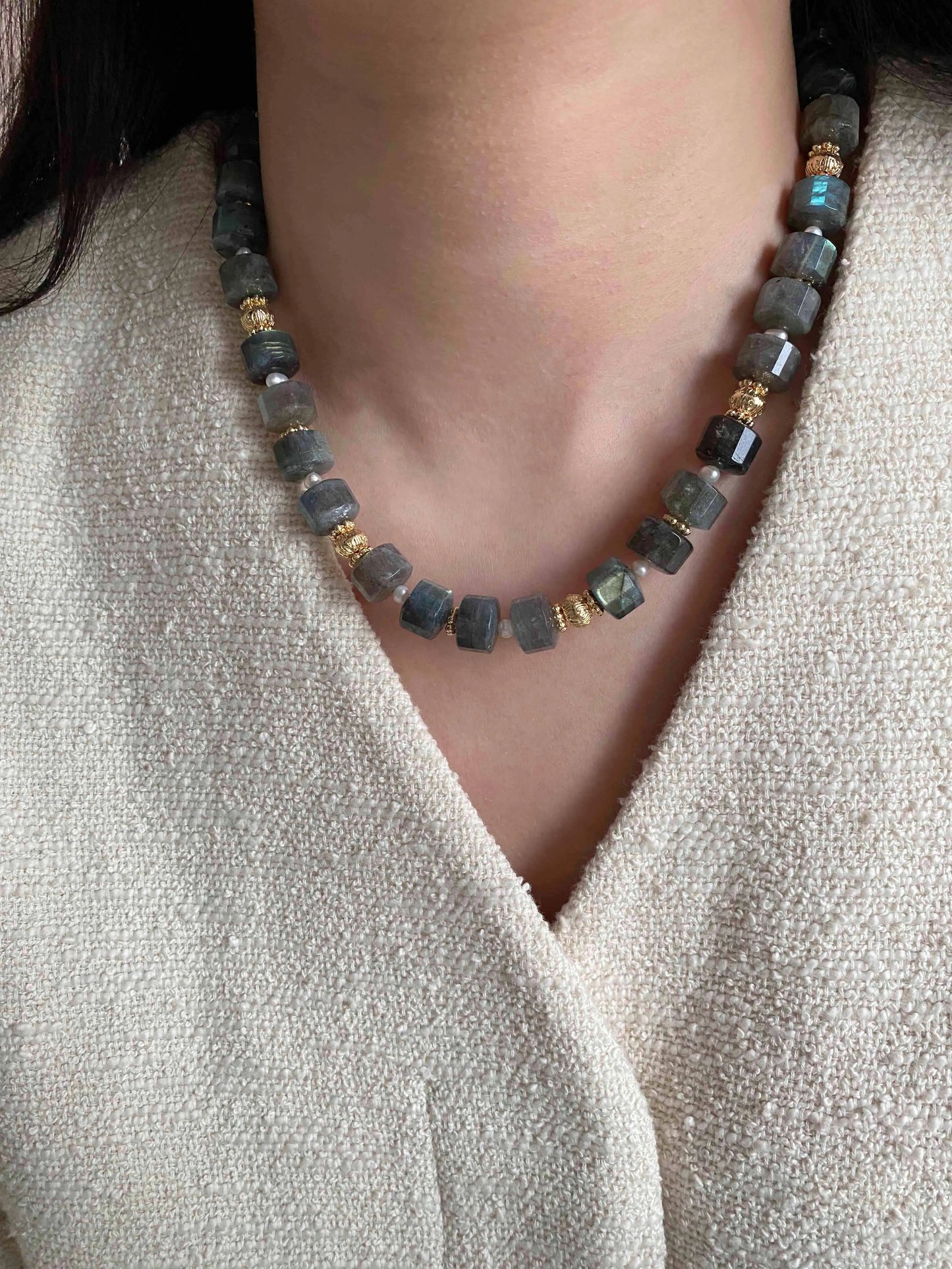Labradorite Necklace with dark beads and gold accents worn by a person against a neutral background