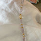Necklace with 5A Amethyst pink and gold beads on a white fabric background
