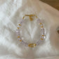 Bracelet with 5A Amethyst purple beads and gold accents on a white fabric background