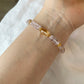 Bracelet with 5A Amethyst pink and gold beads on a wrist against a neutral background