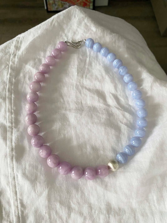 Necklace with pink and blue LaceAgate beads on a white fabric background